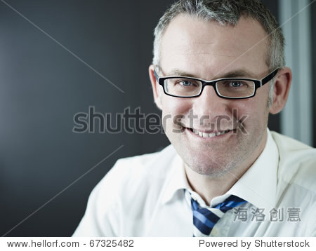 portrait of caucasian mature business man with hand on chin, looking at camera. Vertical shape, head and shoulders, front view, copy space