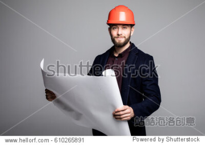 Portrait of an architect builder studying layout plan of the rooms, serious civil engineer working with documents on construction site.