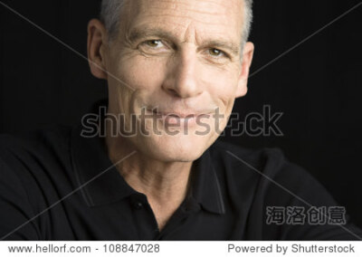 Studio Portrait of a handsome man with grey hair looking to the camera