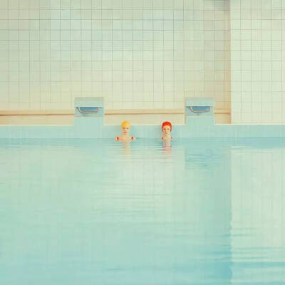 斯洛伐克摄影师Mária Švarbová的《In The Swimming Pool》系列，简单的空间线条、清爽的蓝绿色调与红色形成对比，仿佛安静氛围里隐藏着的强烈情感，时尚复古的拍摄手法，探索人与环境、他人、自身的联系。