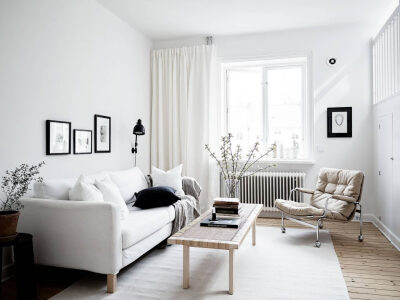白色的房子里，用少量的黑色、灰色做低调的对比。以黄色的木质地板缓和这个无色彩的空间，再以绿色的植物为房子增添一丝活力，生活不外如是。
