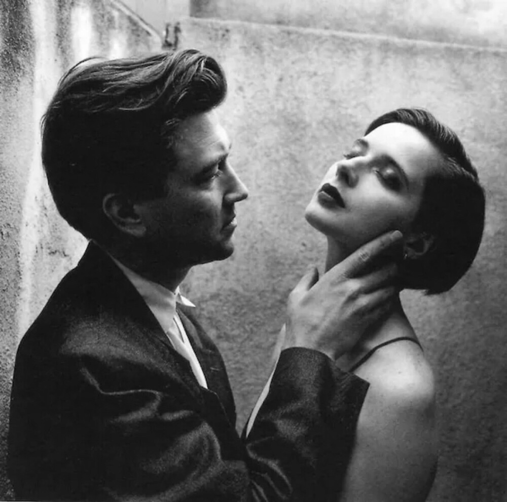 伊莎贝拉·罗西里尼（Isabella Rossellini）， 1952年6月出生于意大利罗马，瑞典著名模特、演员、作家、慈善家。
她曾是著名化妆品品牌兰寇(Lancome)长达14年的形象代言人。她的妈妈是瑞典演员英格丽褒曼，就是卡萨布兰卡的女主，母女俩都是大美人啊！我是看了大卫林奇的电影 蓝丝绒 认识她的。相比与她的母亲，她的美带着一种静谧的神秘感。照片中左为 大卫林奇