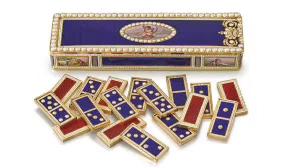 工作之余，大家会否与英国维多利亚女王一样玩上几盘小游戏？多米诺骨牌是女王最爱的游戏之一。这件19世纪初日内瓦制作的纯金珐琅彩镶嵌珍珠多米诺骨牌音乐小盒，原本是为中国市场制作的，但后来成了女王的玩物。今年5月，这个奢华小盒子在日内瓦佳士得拍卖，成交价折合人民币约为290万。