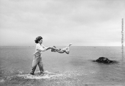 Jackie Swings Caroline nb_90_91. Jackie swings Caroline in the shallows at Hyannis Port in 1959. The source for this image was a vintage 35mm black and white negative.