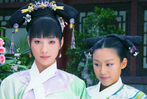 安陵容|常在时期的小鸟宠爱只是昙花一现，时间不长，就如同这个旗头，两边坠着的短流苏。旗头中间那只金钗缀着的两种颜色的珠花和两边的流苏颜色很相配，流苏上两朵紫色的小花也是相铺相成，符合安陵容小家碧玉的气质。