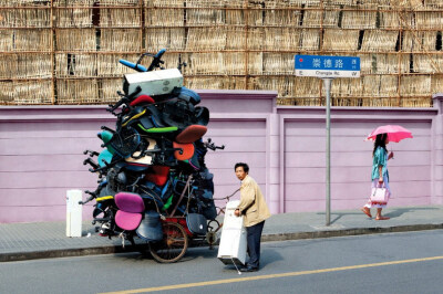 French artist Alain Delorme digitally distorts reality in his series “Totems” in which people are captured around Shanghai with precarious piles of objects.