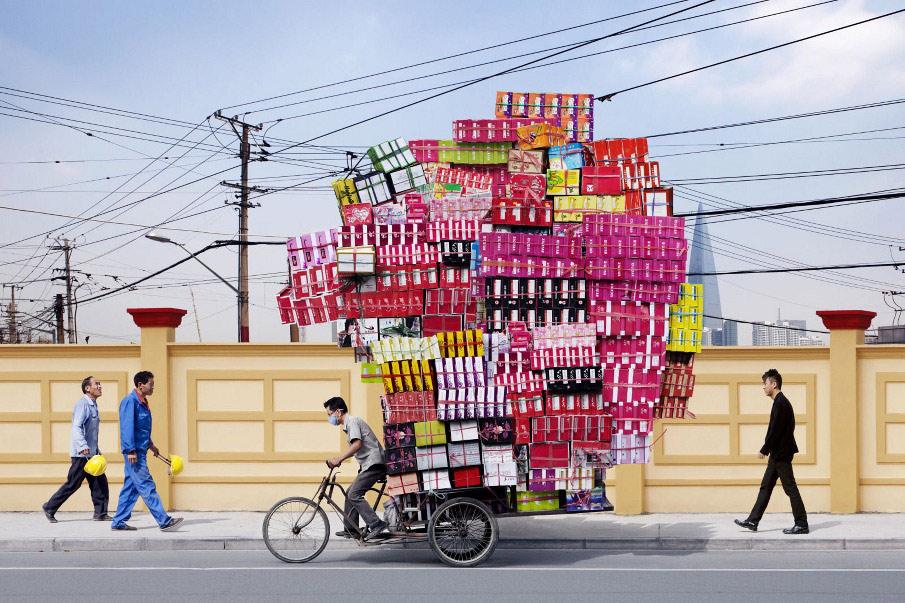 French artist Alain Delorme digitally distorts reality in his series “Totems” in which people are captured around Shanghai with precarious piles of objects.