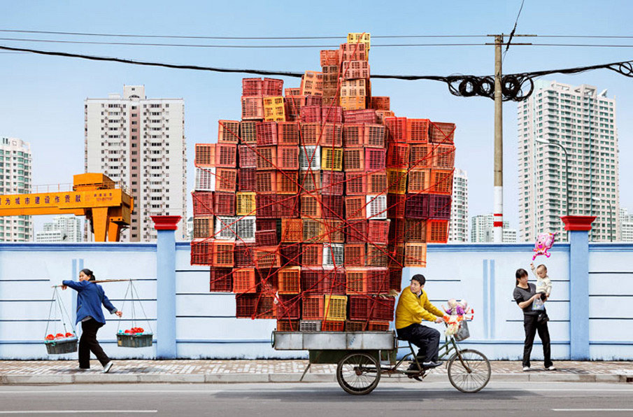 French artist Alain Delorme digitally distorts reality in his series “Totems” in which people are captured around Shanghai with precarious piles of objects.