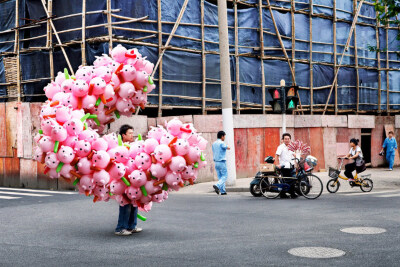 French artist Alain Delorme digitally distorts reality in his series “Totems” in which people are captured around Shanghai with precarious piles of objects.