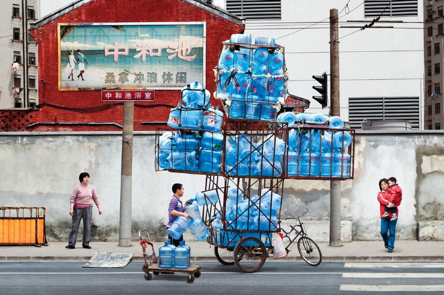 French artist Alain Delorme digitally distorts reality in his series “Totems” in which people are captured around Shanghai with precarious piles of objects.