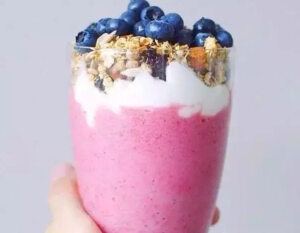 材料：草莓100克、酸奶100毫升、蓝莓一把、燕麦干果一把。
做法：
1.将冰冻好的草莓切块和酸奶一起放入搅拌机中搅拌30秒。
2.把搅拌好的草莓奶昔装杯，一次放入水果块和干果粒，顶部放上蓝莓装饰即可。