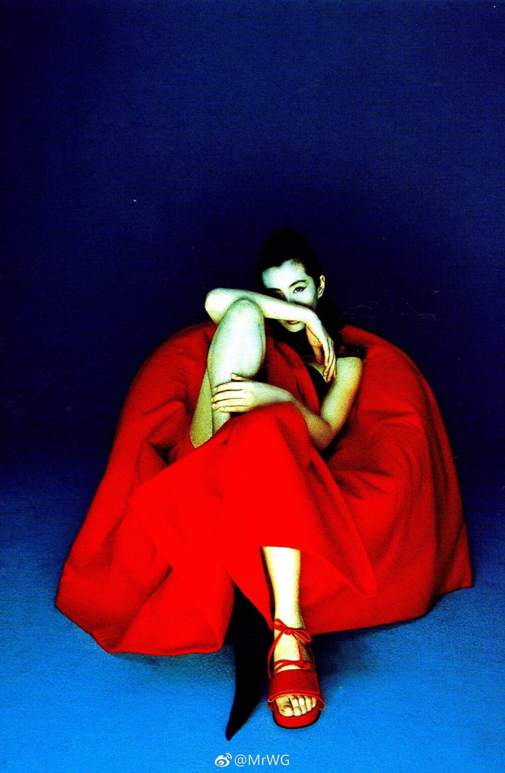 Joey Wong for Vogue Taiwan January 2002 photographed by Lee Shou-Chih.
法国编辑未曾亲睹过王祖贤的电影，替叶锦添画集选照入刊时，却一下相中她为台湾版《沃格》所拍“Drama & Reality”主题editorial残漏的拾遗——
几何形的红绸褶裙来自Issey Miyake，缠绕的流苏金穗，像个诡艳的剪纸娃娃，被尘封于落灰的抽屉内，一身颓废的锦绣华丽；
神巫仙妖般的东方美，冰冷迷幻的墨蓝色，换了现代装的“阿婴”依旧是个不啖凡俗烟火的梦中人，宛若低温的昔日红伶，像达利油画里缺失了时针、分针、秒针的钟，提醒人们时间确确存在，却又不曾逗留在她附近，是恒久不熄的艺术。