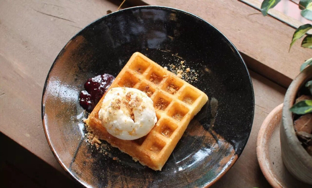 华夫饼（Waffle），120泰铢。新鲜烘烤的松脆华夫饼，配上法国香草冰淇淋，再加上自制的果酱，淋上香甜的蜂蜜后便制作完成。冰淇淋味道不同于平时吃的，一点都不甜腻，口感清淡而绵密，加上蜂蜜刚刚好。冰淇淋顶端还淋撒了饼干碎，口感更有层次。而最画龙点睛的部分，便是这小小的果酱。果酱一共采用5种莓制作而成，包括草莓、蓝莓、覆盆子、蔓越梅等，最后加入兰姆酒一起炖煮，可保期一周，所以果酱都是新鲜制作而来。加上酸甜清爽的果酱之后，目前这是我最喜欢的华夫饼，一个人把整盘都吃光了。