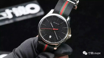 GUCCI古驰
G-Timeless腕表男款
表壳：直径40毫米抛光不锈钢
表盘：黑色太阳光泽菱形格纹表盘
防水：30米
机芯：ETA石英机芯
功能：时分秒，日期显示
表带：黑色尼龙表带饰以“绿红绿”条纹
表扣：不锈钢针扣…