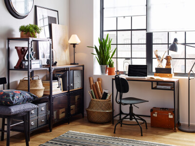 White workspace with wood floors and industrial style black metal and wood shelving and desk.