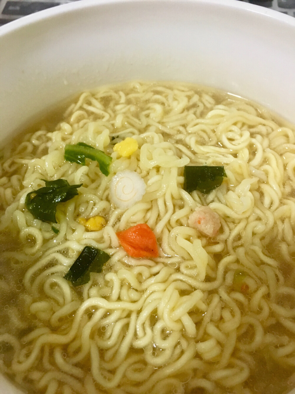 海鲜方便面近景,有螺旋纹路的鱼板,虽然很薄一个,哈,小时候看日本动画