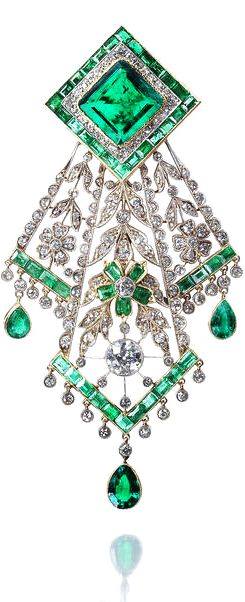 An emerald and diamond handkerchief brooch, circa 1910.