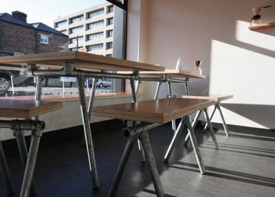 用金属管搭建的长桌、长椅，简约的设计为咖啡馆增添了现代的工业风元素。