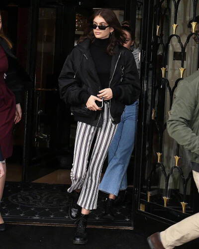 Kaia Gerber 在巴黎外出街拍。身穿的条纹裤出自品牌PAIGE，黑色夹克出自Alexander Wang ，脚穿的是Dr. Martens。 ​​​