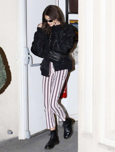 Kaia Gerber 在巴黎外出街拍。身穿的条纹裤出自品牌PAIGE，黑色夹克出自Alexander Wang ，脚穿的是Dr. Martens。 ​​​