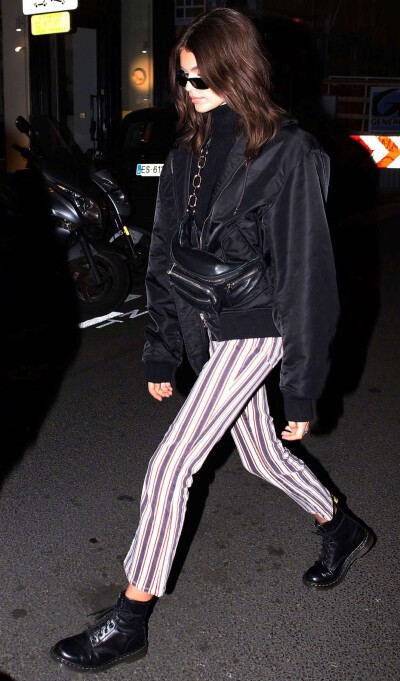 Kaia Gerber 在巴黎外出街拍。身穿的条纹裤出自品牌PAIGE，黑色夹克出自Alexander Wang ，脚穿的是Dr. Martens。 ​​​