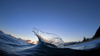 汹涌的海浪风景图片高清宽屏壁纸。浩瀚无边的湛蓝的海洋，一道道波浪不断涌来，撞击在岩石上，发出了天崩地裂的吼声，喷溅着雪白的泡沫。 