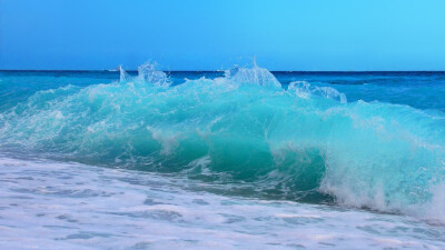 汹涌的海浪风景图片高清宽屏壁纸。浩瀚无边的湛蓝的海洋，一道道波浪不断涌来，撞击在岩石上，发出了天崩地裂的吼声，喷溅着雪白的泡沫。 