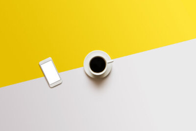 咖啡和手机在白色黄色的颜色块背景 ...