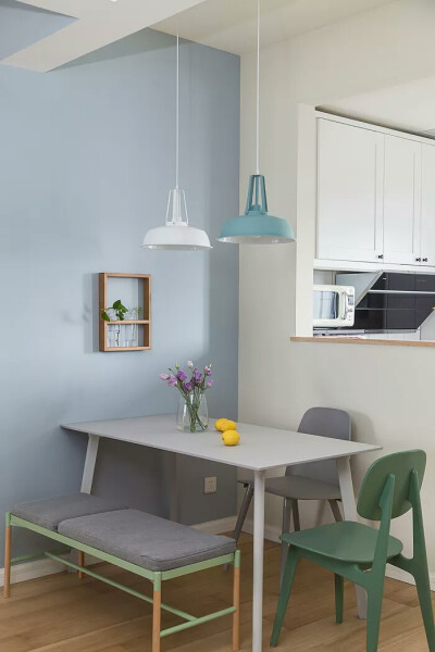 图5▲蓝色的背景墙上做了一个小小的木质框架，摆上小小的绿植作为装饰，与餐桌上紫色的插花相互呼应，不失为一处独特的好风景，将用餐区的优雅之气发挥得淋漓尽致。
