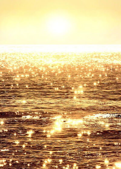 Alluring sunlight reflects upon the glassy ocean waves casting dazzling flashes of lights resembling sparkling diamonds in the sea. A photograph by artist Michael Rock