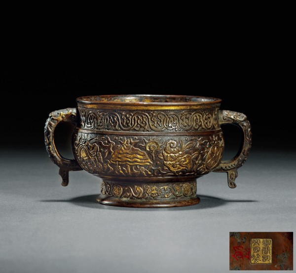 明 胡文明制铜鎏金八宝纹簋式炉，尺寸：高8cm；通径16cm；口径11.2cm；重572.3g?？钍叮涸萍浜拿髦?说明：此炉作簋式，传自上古鼎彝之器。阔口，颈微束，整器錾细密鱼子地，纹饰分为三段：颈部起卷草纹，腹部装饰一周鎏金八宝纹，底部做缠枝花卉纹。双耳之上亦有螭龙纹。底部有“云间胡文明制”六字鎏金篆书款。整炉工艺精湛，皮壳古朴。西泠印社2018年春季拍卖会，文房清玩·古玩杂件专场