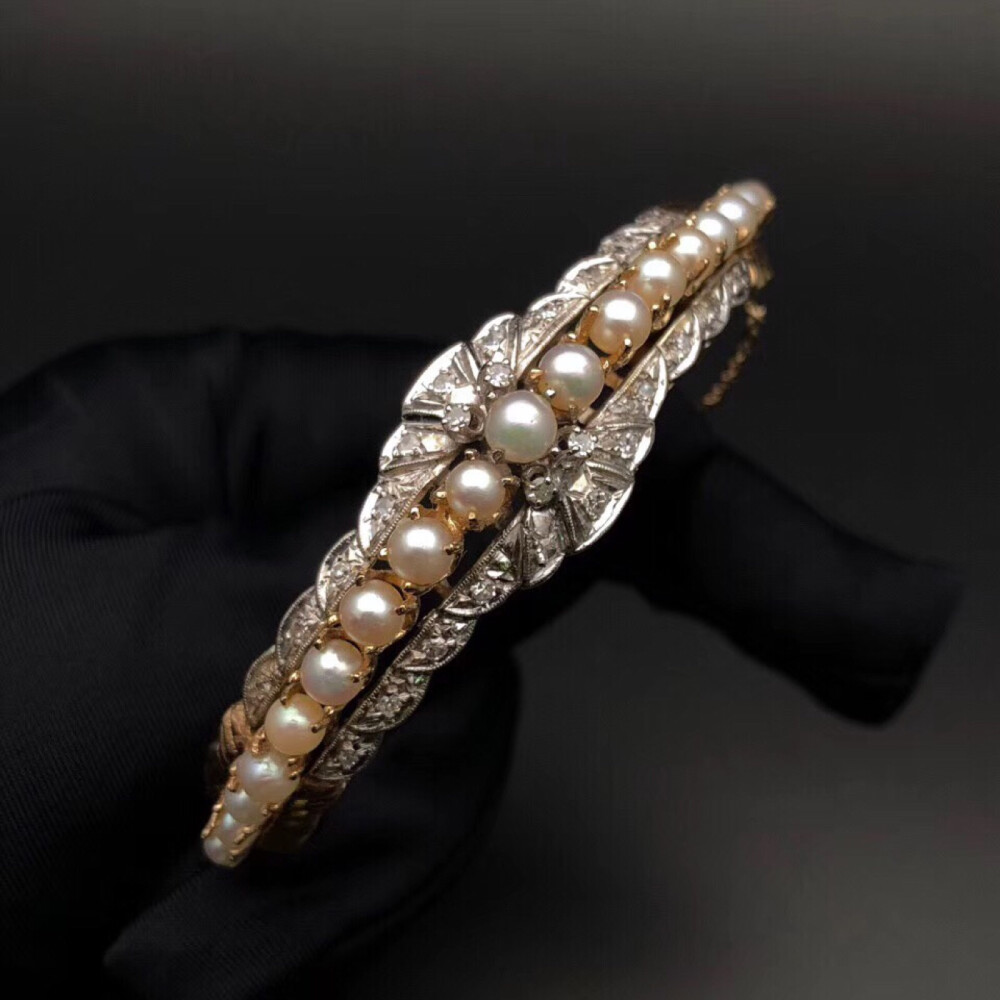 14k金珍珠钻石手镯。双色金制作，中轴线以珍珠一线排列，两侧雕花配镶钻石，与珍珠搭配特别地优雅，品相完整。