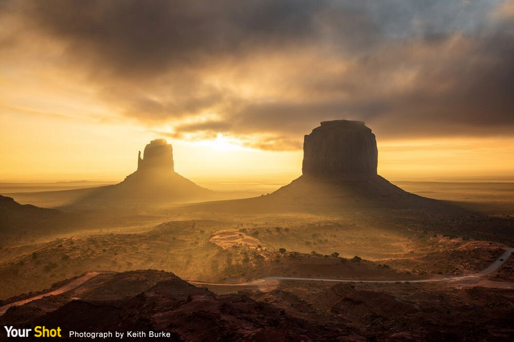 金色尘土
就算是在晴朗的早晨，纪念碑谷（Monument Valley）的日出也是不可不看的风景。幸运地，这个早晨有美丽的云层以及薄雾，让我的旅游经验变得更加美好。尘土状的金色薄雾在日出时分弥漫了整个大地，因此我将这张照片称为「金色尘土」。这个早晨真是惊人，希望我有将当时的美景和感动呈现给大家。（摄影：Keith Burke）