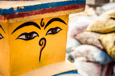 Buddha eyes, also known as wisdom eyes on a stupa in Nepal. Background of construction materials (sandbags), one of the many construction sites present in Nepal after the 2015 earthquake.