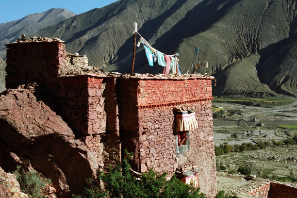 Tibetan monk looking at cell window.