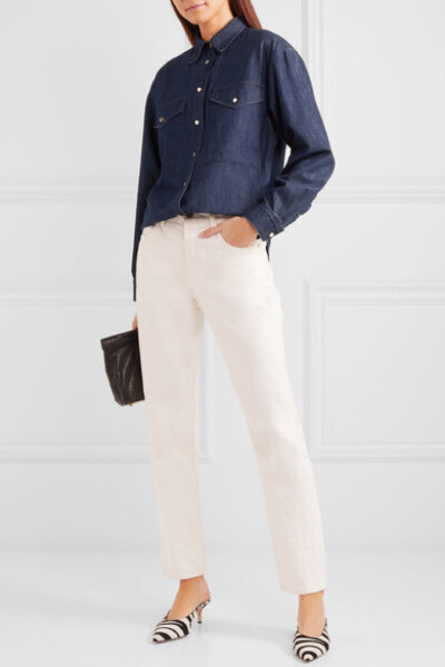 洛杉矶品牌 Goldsign 将当地的现代建筑风格和 1990 年代极简主义相结合，为旗下服装带来了源源不断的设计灵感。出自该品牌的这款衬衫以深蓝色牛仔布制成，廓形宽松，衣摆前短后长，衣身上点缀着亮泽的金色纽扣。若想…