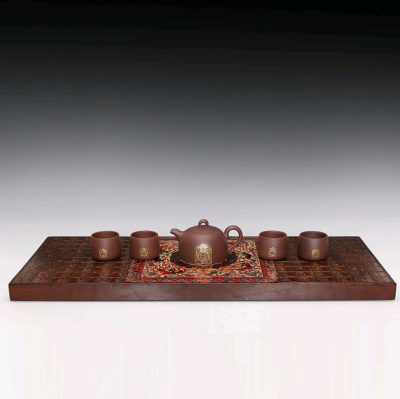 《盛世和光·敦煌漆器茶器》作品以千年敦煌文化为灵魂，采用大漆髹饰技艺、紫砂髹漆技法制作而成，共包括一壶四杯一个茶台。