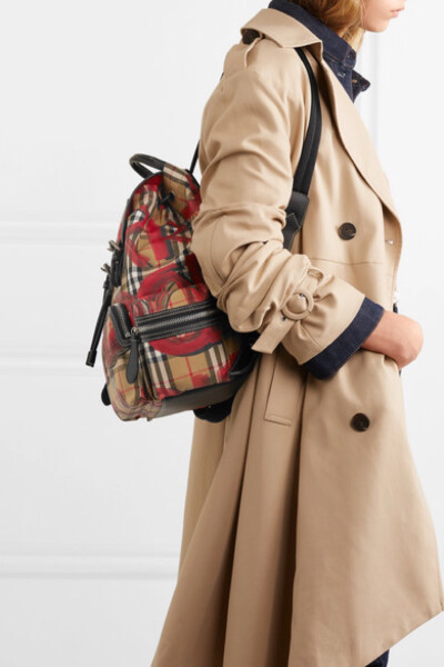 Burberry 本季为旗下的军装风双肩包披上仿旧复古格纹倪裳——其上的涂鸦印花则出自这一英伦时尚屋于伦敦盛大举行的 2018 秋冬系列。这款包袋采用与品牌经典风衣同样的华达呢面料制成，其上配有皮革边饰搭扣，并以手…