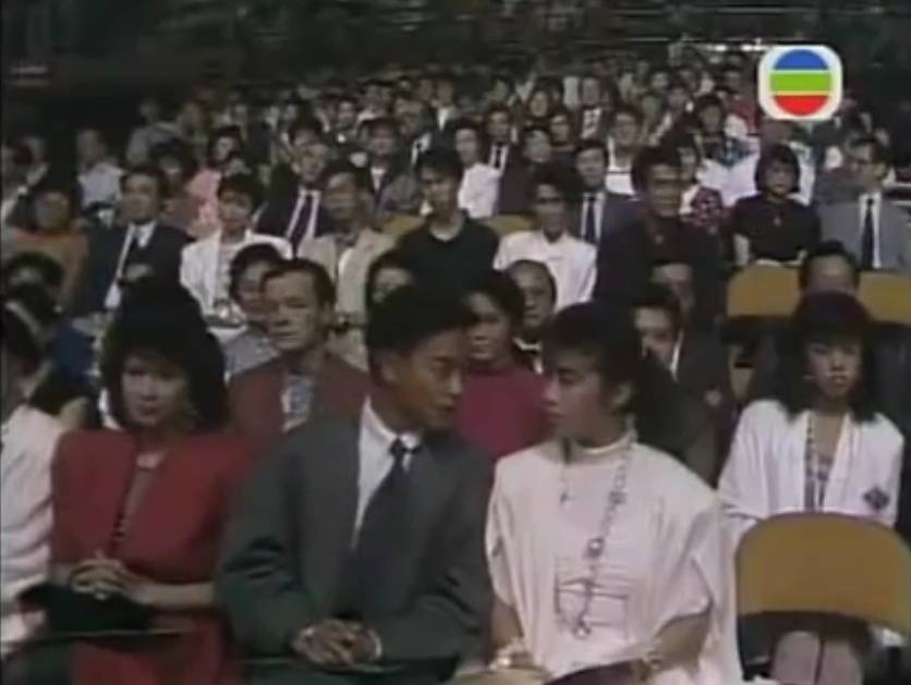  1986年7月13日，第五届新秀歌唱大赛在湾仔新伊馆举行总决赛。#张国荣#以观众身份坐在第一排全场捧场。当届冠军为文佩玲，亚军许志安、季军黎明。另外还有关淑怡、黄翊等进入决赛。决赛中黄翊和罗艾文分别选了张国荣的《Stand Up》和《打开信箱》。当晚他与大伙一起去跳舞Happy，结果喝得醉醺醺与吴婉芳共舞，被八卦传媒拍照登了报。
（歌唱比赛视频：http://t.cn/RghnoI8）