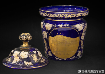 #独角鹿Antique#这套奢华的水晶套件来自1880年代的波西米亚地区，为德国定制纪念款式，含长颈瓶、托盘等四件，高雅华美，双色描金葡萄藤蔓满布帝王蓝水晶之上，水晶之中有精细描金画面，刻画德国水城巴登-巴登的名胜…