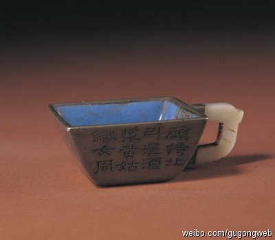 【锡套紫砂里方斗杯】清道光，高2.7cm，口径5.8×5.8cm，底径3×3cm。 此杯外体为锡质，方斗形，白玉柄，内里为江苏宜兴紫砂挂蓝釉。锡套上刻有“愿持此斗浥酒浆，黄姑织女同飞觞”诗句。