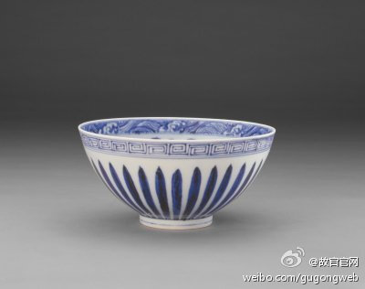 【青花菊瓣纹碗】明永乐，高10.3cm，口径21.2cm，足径7.6cm。清宫旧藏。碗敞口，瘦底，为鸡心碗。通体青花纹饰。碗心双圈内饰折枝枇杷纹，内壁饰缠枝花纹，内口饰海水纹。外口饰回纹，外壁饰菊瓣纹