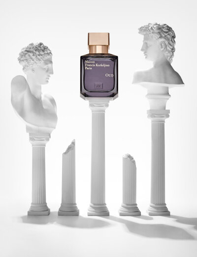  Maison Francis Kirkdjian fragrance bottle shot creatively for editorial with greek statues on top of columns. Creative still life photography shot by London based photographer Josh Caudwell. 