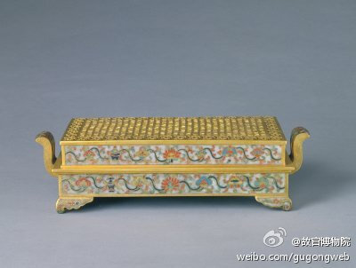 掐丝珐琅八宝纹长方熏炉，明万历，御用监制造，通耳高9.1cm，盖面26.8×14.4cm，底面25.5×13.2cm。熏炉呈长方形，朝冠式双耳，垂云式四足。四壁以灰白色珐琅釉为地，饰掐丝彩釉八宝勾莲纹，盖面无釉，作铜鎏金镂空纹…