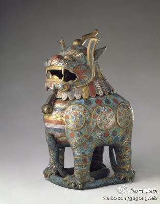 掐丝珐琅甪端，明，御用监制造，通高36.5cm。清宫旧藏。甪端昂首，独角，二目圆睁，双耳，口微张，以为散香之用，四爪为器足作直立状，圆形垂尾，足下踏掐丝珐琅蛇。通体饰豆绿色珐琅地，用红、黄、蓝、白等色珐琅填饰纹样。甪端的头部可掀开，以便放置熏香。