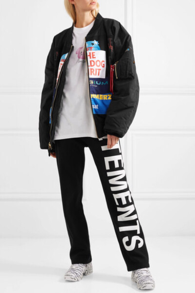 Vetements 每次推出的合作系列都潮范十足，迅速霸占街拍高地，如今品牌则与 Alpha Industries 再次携手重新演绎 MA-1 飞行员夹克。它采用黑色软壳面料制成，配有罗纹边饰，错落拼接而成的贴花让人感觉这是从标语 T …