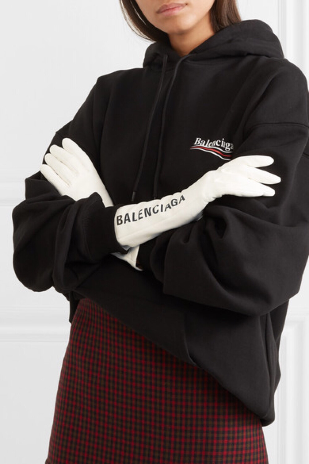 Balenciaga 从醒目的公共交通指示牌中汲取灵感，设计了新款品牌 Logo，酷感十足的图案辨识度超高——这款白色手套上就印有黑色的新标志。它采用无比柔软的皮革打造，真丝衬里确保其穿脱方便。不妨搭配同品牌千鸟格大衣或西装式外套。