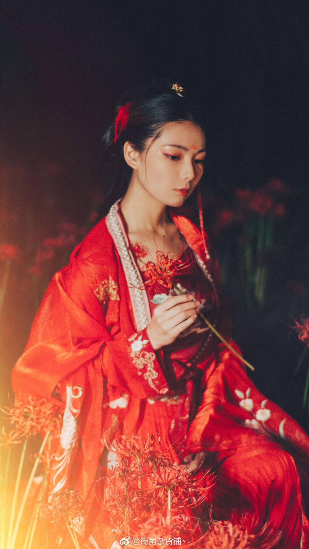 《曼珠沙华》
下 「花篇」
她本是掌管忘川河畔曼珠沙华花期的天女，因一次不慎误了花期犯下天律被天神罚贬凡间，花开之季便千年为花，去渡那忘川河上的魂，花落时节则千年为人，去渡那尘世凡间的人，如此轮回。
这一轮，她已在人间苦熬了九百余载孤独岁月，腕上逐渐清晰的刺青提醒着她，花期将至了。她回到忘川河畔，却望见茫茫花田之中，一位少年孑孑独立，发如乌墨，目有星河，一袭青衣，笑意浅浅眼波微转，顾盼之间她竟从心底生了情。她恨，恨自己在这茫茫凡世孤独了近千年，却偏偏在将要化花之时遇见他，但她也明白，这是她注定要品尝的痛苦，命该如此。她苦笑：“我便要离开这世间了。”他微怔，蹙眉久久方才开口：“彼岸之花，花叶本不得相见，想是哪位天女误了花期，才有你我一会。”她恍然，原来什么求不得爱别离，此一遇竟是全因了她自己，是缘，亦是劫，是奖赏，亦是酷刑。
花田之中，一株沙华正以最惊艳之姿盛开，一位青衣少年傍着她席地而坐，手执一柄洞箫，说起了流转千年的情意。
摄影 后期：@街角杂货铺丶
出镜 ：小璇
文案 ：@-仙儿啊仙儿啊仙仙儿啊- 