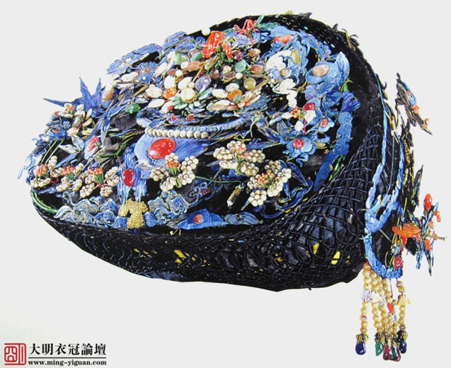 【钿子】—清—（清宫藏品-文物号 故59666）——高17cm ，直径24cm 。帽胎以黑色丝绒缠绕铁丝编结而成，形似覆钵。由珍珠、珊瑚、玉石、碧玺等珠石组成各色花饰，点翠铺衬，铜镀金底托。花饰组成有吉庆祥瑞，有寿、蝴蝶、连钱、仙鹤、灵芝、兰花、寿桃、如意、笔、葫芦、花篮、蜻蜒、天竺、石榴、祥云等，意寓子孙万代、长寿如意。钿子是清代妇女的头饰，穿戴时多与吉服相配。