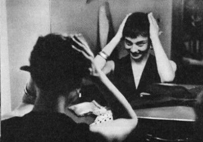 Audrey Hepburn applying makeup in her dressing room, 1954. 